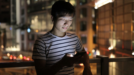 Young man using mobile phone in city