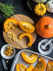 Orange fresh pumpkin slices on wood board 