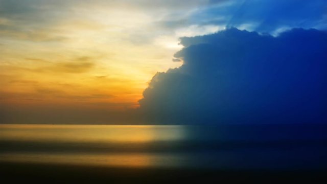 The sun is setting behind the cloud over the ocean. Timelapse FullHD 1080p.