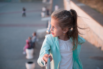 Portrait of a beautiful little girl lit by the setting sun