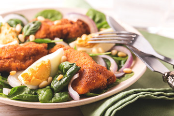 Spinach salad with egg, chiken, onion and pine nuts