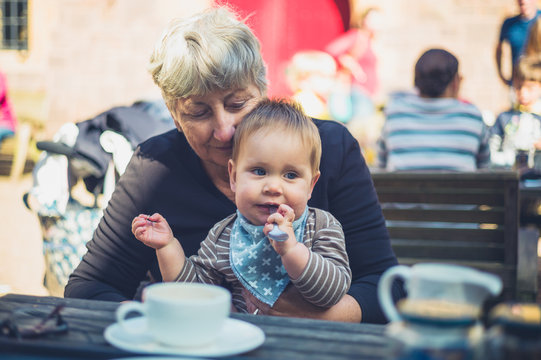 Baby with grandmother at table outside