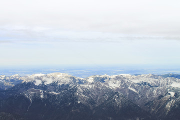 View of a mountain range with snow and clouds
