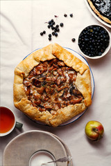 Chanterelle mushroom galette and blueberry tart on linen fabric. Close up view. Harvest baking time concept.