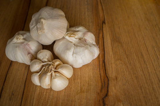 The garlic on wood Table in kitchen close up image