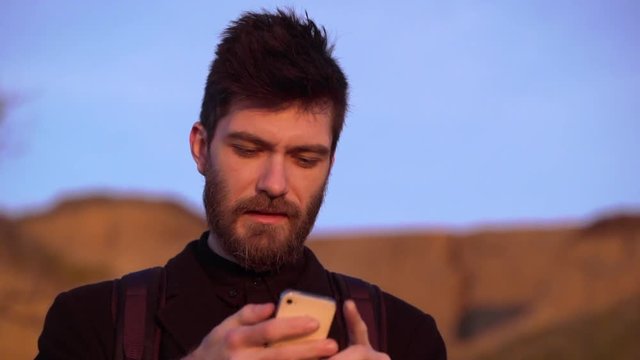 Caucasian man holding phone making photo sunrise