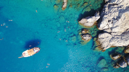 Fototapeta na wymiar August 2017: Aerial drone photo of paradise beach of Traganou with small caves and turquoise clear waters, Rhodes island, Dodecanese, Aegean, Greece