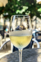Glass of white wine on terrace, selective focus