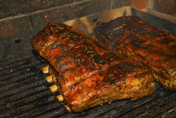 pork ribs marinated grilling on hot burning charcoal barbecue close-up