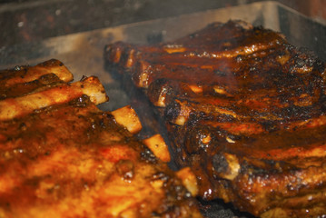 pork ribs marinated grilling on hot burning charcoal barbecue close-up