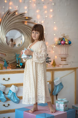 child girl with  gift on presents , golden background, beautiful real bedroom