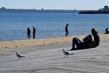 MELBOURNE, AUSTRALIA - AUGUST 14, 2017 - People relaxing on st. Kilda the beach