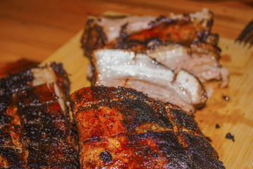 pork ribs marinated grilled on charcoal barbecue and cutted on wooden board close-up