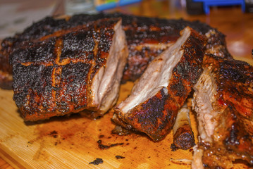 pork ribs marinated grilled on charcoal barbecue and cutted on wooden board close-up
