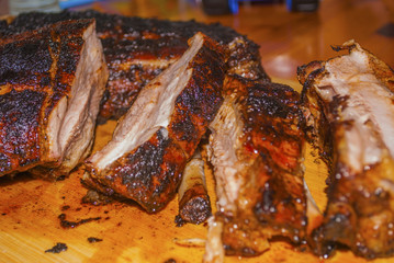 pork ribs marinated grilled on charcoal barbecue and cutted on wooden board close-up