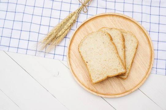 Whole wheat bread on a wooden plate.