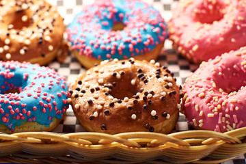 Colorful donuts in different colors in a whicker basket