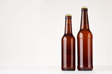 Set of brown longneck beer bottles 500ml and 330ml mock up. Template for advertising, design, branding identity on white wood table.