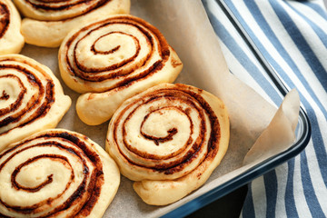 Raw cinnamon rolls in baking dish, closeup