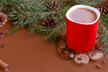 Obraz na płótnie Canvas Christmas traditional hot drink cocoa in red cup, fir branches and cones on the dark wooden background copy space