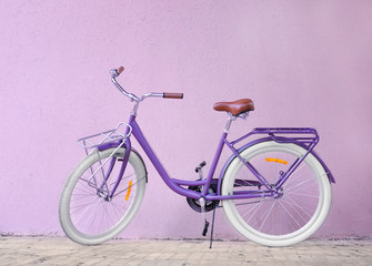Fototapeta na wymiar Modern beautiful bicycle standing on color wall background
