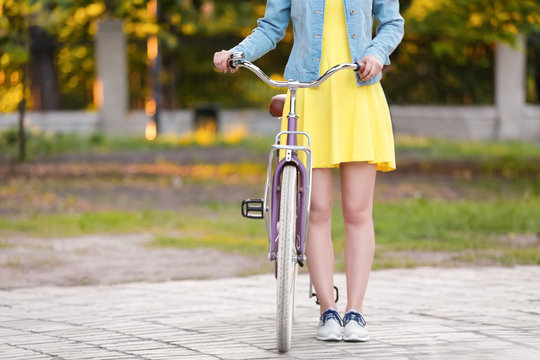 Beautiful young woman with bicycle, outdoors