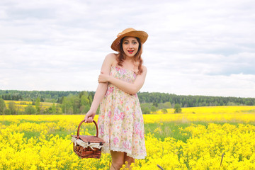 girl in a field of flowers with basket and a hat