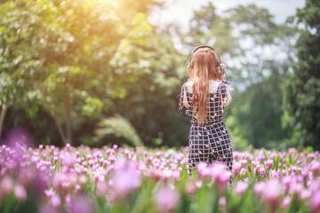 Beautiful girl, technology and leisure concept - girl with headphones lying on natual and listening...