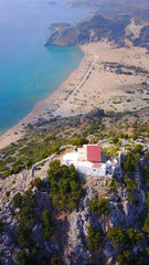 Fototapeta premium August 2017: Aerial drone photo of famous Tsabika monastery overlooking iconic Tsabika bay from the cliff with clear turquoise waters, Rhodes island, Aegean, Dodecanese, Greece