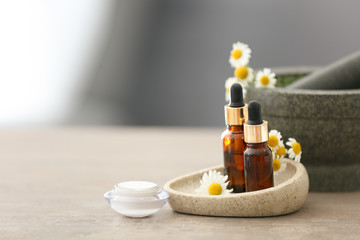 Fototapeta na wymiar Cosmetics with chamomile extract on table
