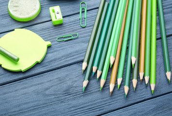 Naklejka premium Sharp green pencils and office supplies on wooden table