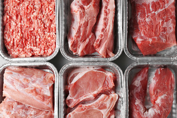Containers with pieces of different fresh meat