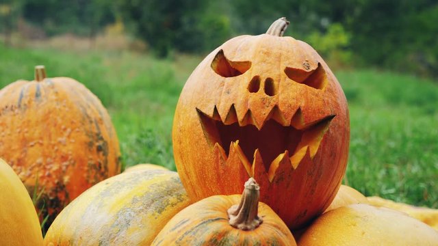 A woman puts a ready-made pumpkin with a carved scary face