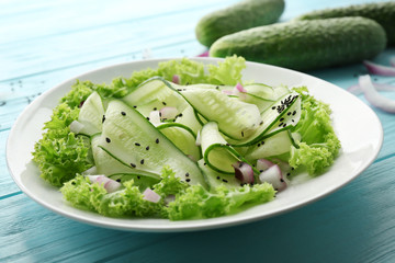 Fresh vegetable salad with cucumbers in plate on table