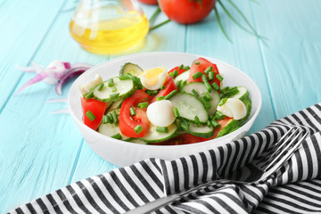 Healthy salad with cucumbers and eggs in bowl on table