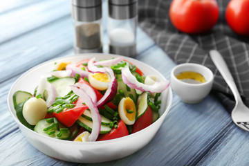 Healthy salad with cucumbers and eggs in bowl on table