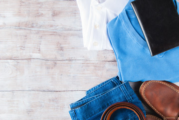 Man's clothes flat lay with blue jeans, T-shirt, pullover, leather shoes and belt