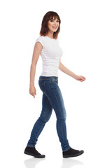 Fototapeta premium Smiling Young Woman Is Walking And Looking At Camera