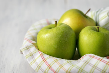 Green apples in drops of water on a wooden table