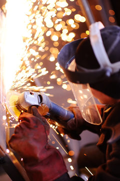 Worker with angle grinder.Sparks from welding or from a torch for metal