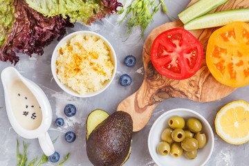 ingredients for a bright vegetable salad with couscous, top view, vegan lunch.