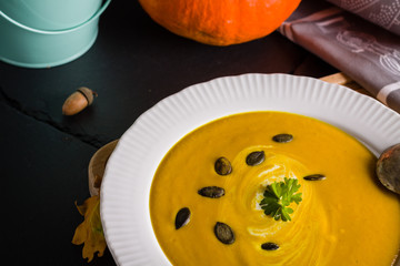 Autumn background scene of pumpkin soup with pumpkin seeds.