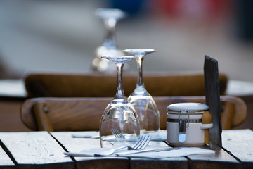 Fototapeta na wymiar Empty wine glasses on the table served for lunch, dinner in cafe, restaurant outside or on terrase