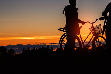 man with a bicycle at sunset.