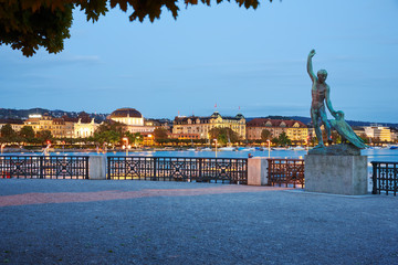 Zürich Twilight Bürkliterrasse Parkanlage Blick auf beleuchtetes Utoquai Skulptur Canymed - obrazy, fototapety, plakaty
