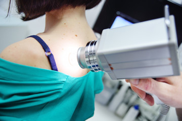 Fototapeta premium melanoma diagnosis. examination of birthmarks and moles.the doctor examines the patient's mole