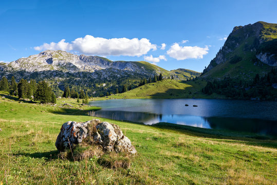 Bergsee Seebergsee Bergmassiv Alpwiese Felsbrocken blauer Himmel Wolken