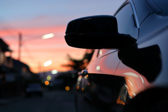 luxury vehicle black car with blur twilight dramatic sky, image selective focus on side mirror
