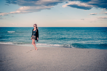 Femme sur la plage au coucher du soleil