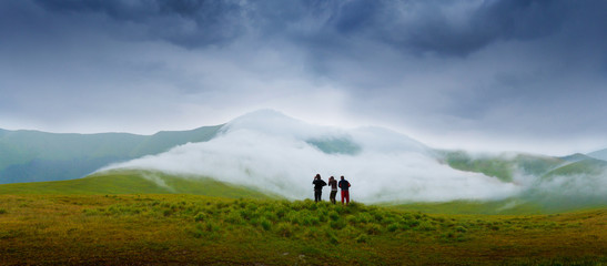 Hiking campers photographing a natural phenomenon - the clouds that roam the mountains. Concept...